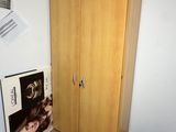 a closet in the corner of a room with posters on the wall