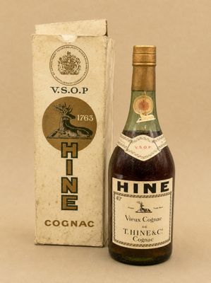une vieille bouteille de vin posée à côté d'un carton de vin