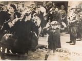 a black and white photo of a little girl standing in front of a crowd of people