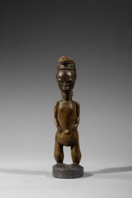 une statue en bois d'un homme avec un chapeau sur la tête