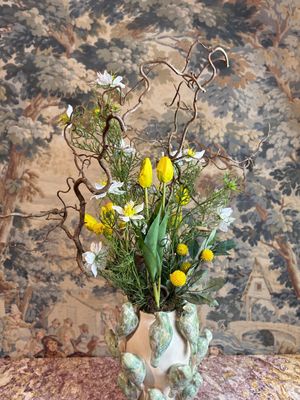 un vase contenant des fleurs, posé sur une table
