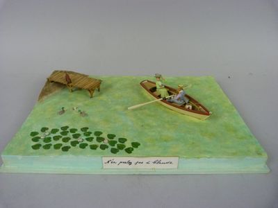 figurine représentant un homme dans un bateau avec un chien et un autre homme dans un bateau sur un lac