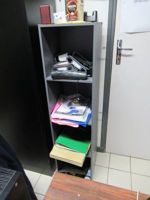 une bibliothèque noire sur laquelle sont posés tout un tas de livres