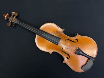 un gros plan d'un violon posé sur une surface noire