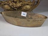 a large brass bowl with a statue on top of it