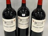 three bottles of red wine are lined up on a white surface