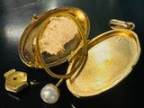 un porte-clés en or contenant une perle, posé sur une table