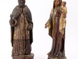 deux statues en bois représentant une femme tenant un bébé dans ses bras et un homme tenant un enfant