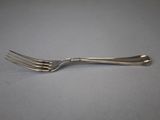 silver plated fork on a gray surface