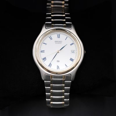 a silver watch with roman numerals on the face