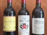 three bottles of wine are lined up on a black table