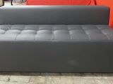 grey leather sofa bed in a room with a red wall