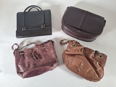 trois sacs à main sont posés les uns à côté des autres sur une table