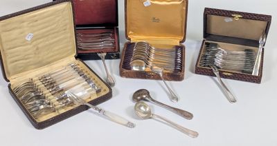 Plusieurs pièces d'argenterie sont disposées dans une vitrine posée sur une surface blanche