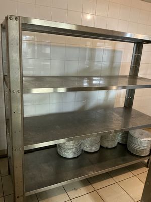 a metal shelf with plates on it in a kitchen