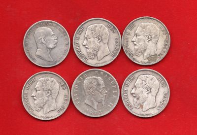 six types différents de pièces d'argent sur un fond rouge