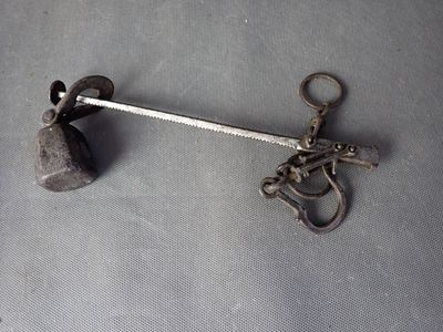 un crochet métallique auquel est fixé un marteau