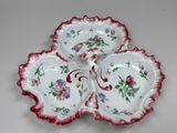 three red and white plates with flowers on them on a table