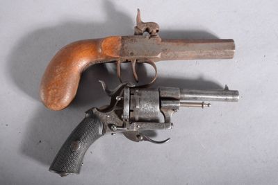un vieux pistolet avec une poignée en bois sur une surface blanche