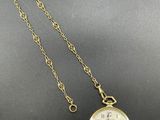 a close up of a pocket watch on a chain on a table