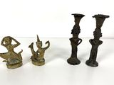 three bronze figurines sitting on a white surface with a white background