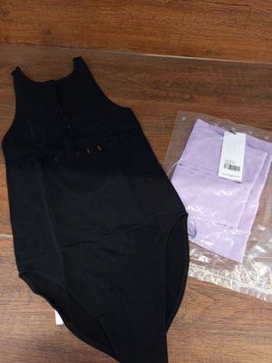 une robe noire et une chemise violette sur un parquet