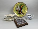 a plate with a bird on it next to a bowl and a plate with a bird on it