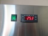 a digital clock on the side of a stainless steel refrigerator