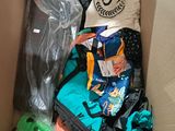 a cardboard box filled with clothing and a stuffed animal