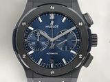 La montre possède un cadran bleu et un bracelet en cuir noir.