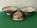three silver plated dishes on a green table with a green cloth