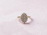 un gros plan d'une bague en or sertie de diamants sur un fond rose