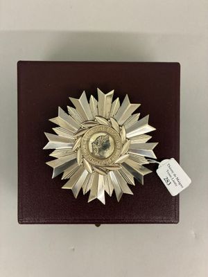 une petite boîte ornée d'une médaille, posée sur une table