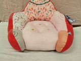 une peluche assise sur un oreiller