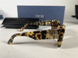 leopard print sunglasses on a white surface with a blue box in the background