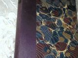 a book with a purple cover sitting on a lace tablecloth