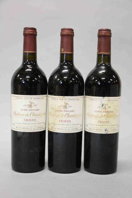 trois bouteilles de vin rouge posées côte à côte sur une table