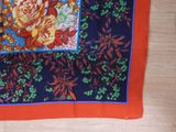 a close up of a red and blue scarf with orange flowers