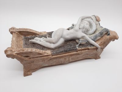 une sculpture représentant une femme allongée sur un lit