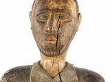 an old wooden statue of a man with a broken face