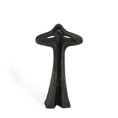 une sculpture noire représentant une croix sur fond blanc
