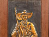 a plaque of a man with a rifle on a wall
