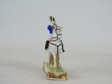 a figurine of a man riding a horse on a white surface