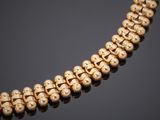 a gold necklace with skulls on a black background