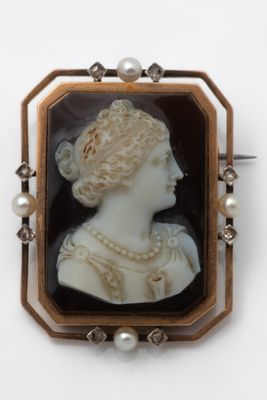 an antique cameo of a woman with pearls in her hair