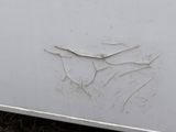 a white refrigerator with a crack in the door