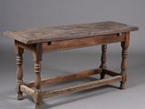 une vieille table en bois avec des pieds tournés et un plateau en bois