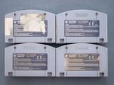 four nintendo game cartridges sitting on top of each other