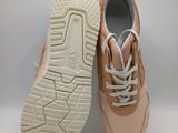 the sole of a pair of beige sneakers on a white background