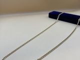 a close up of a necklace on a table with a pen
